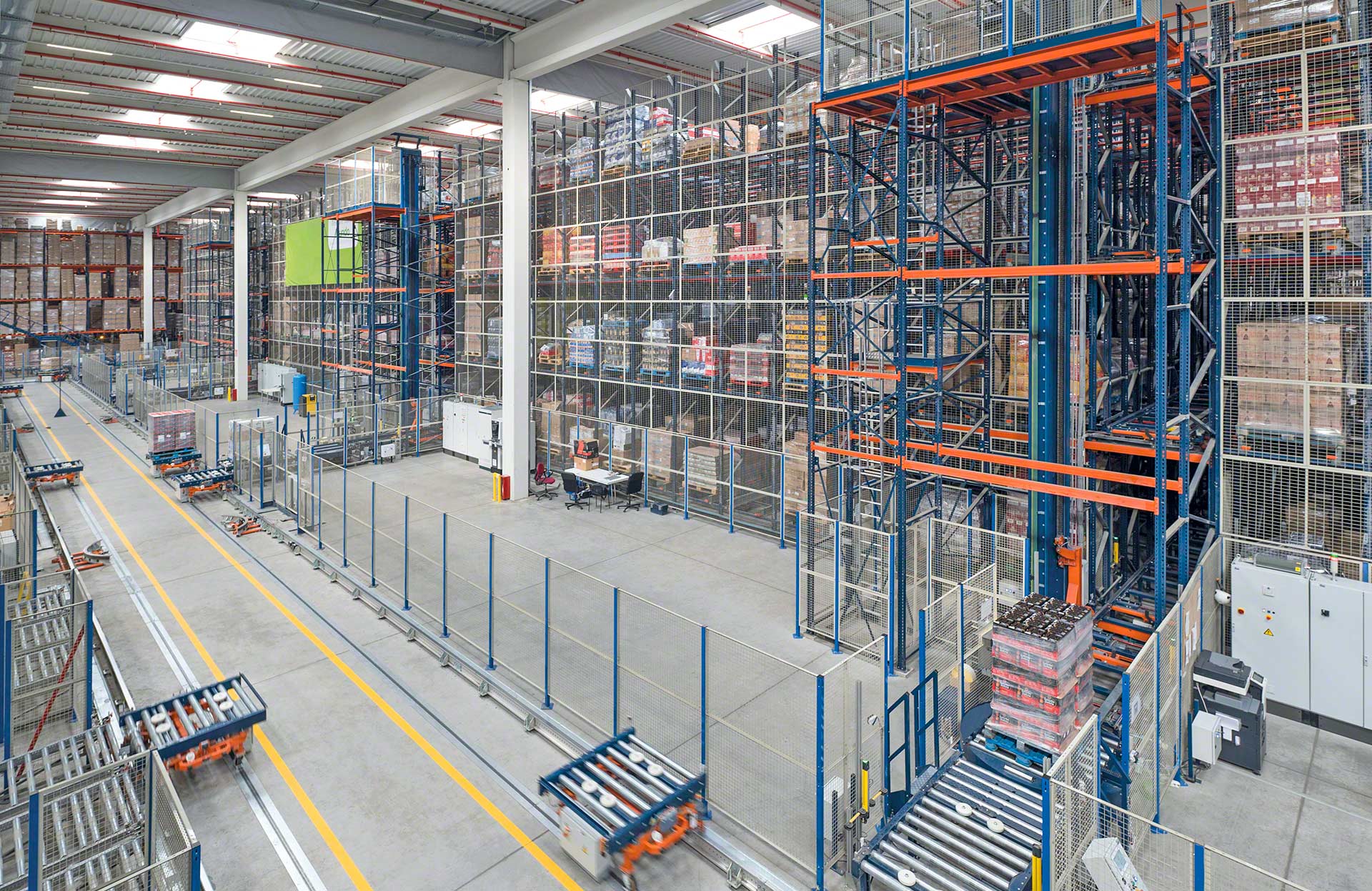 Pallet elevator lifts incorporate a roller or chain conveyor to transfer loads