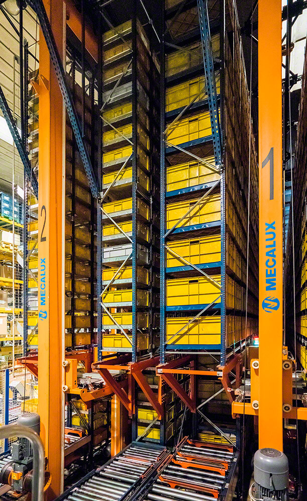 In each one of the aisles, a twin-mast miniload stacker crane circulates